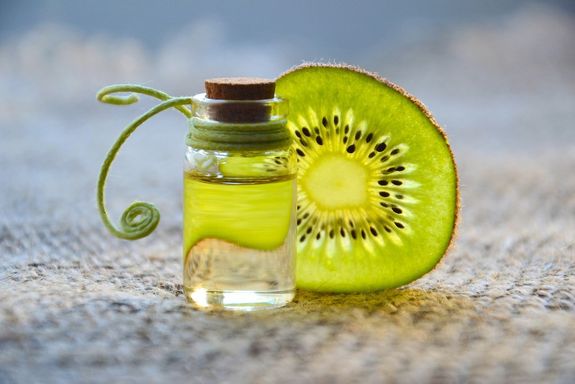 frasco de perfume con una rodaja de kiwi